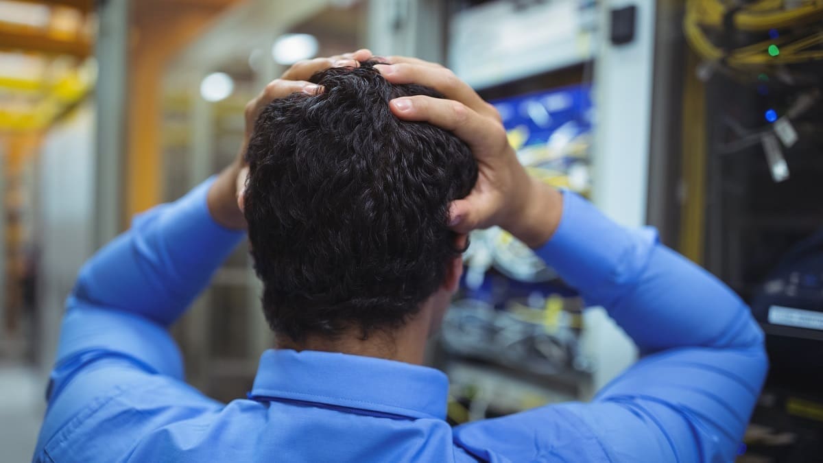 Stressed technician working on server maintenance Disruptive IT staff challenges and how Optical LAN can help